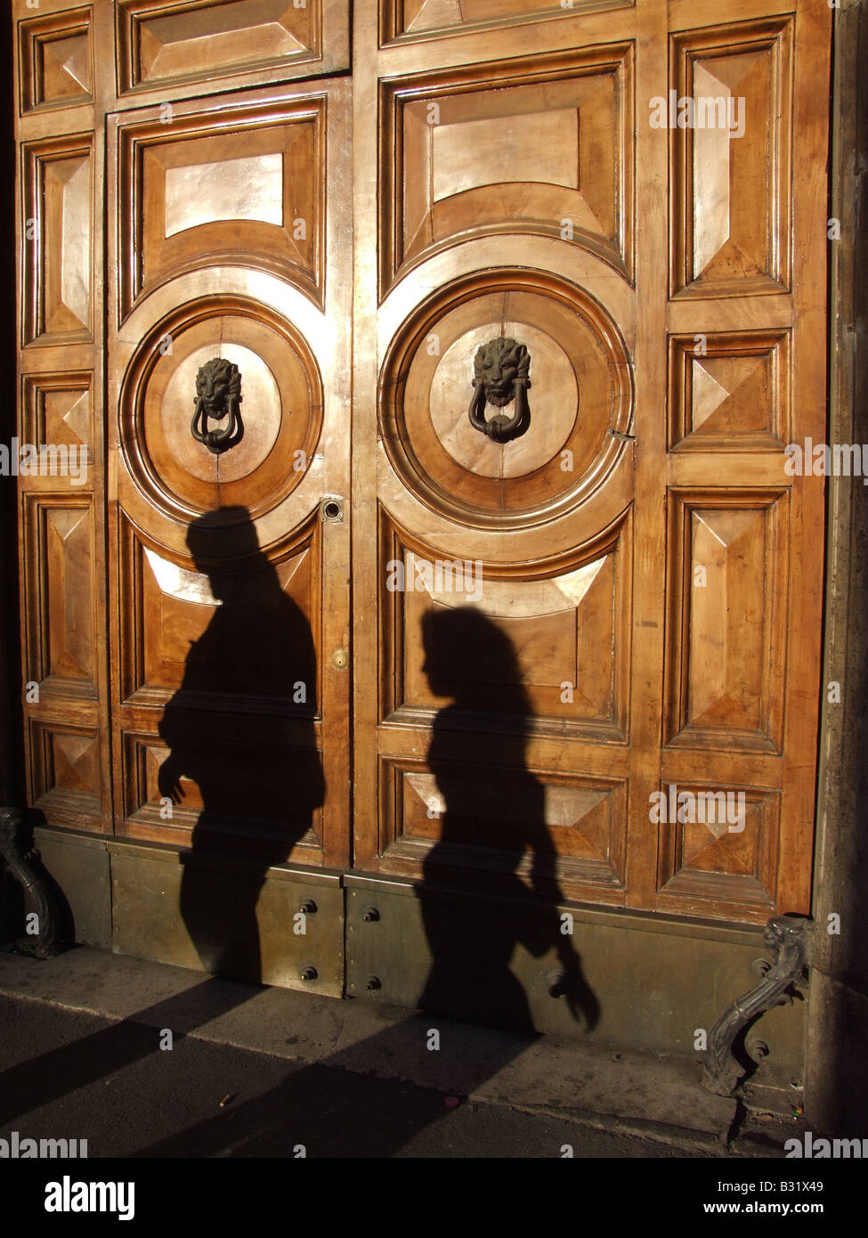 La gente camminare passato intagliata in legno porta in città Foto Stock