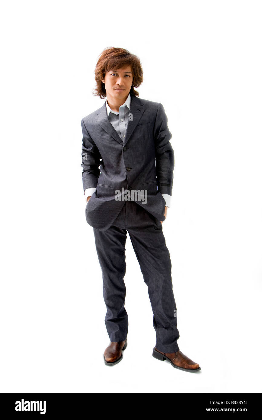 Giovani Asian business uomo vestito in grigio di un abito gessato con le mani nelle tasche isolato Foto Stock