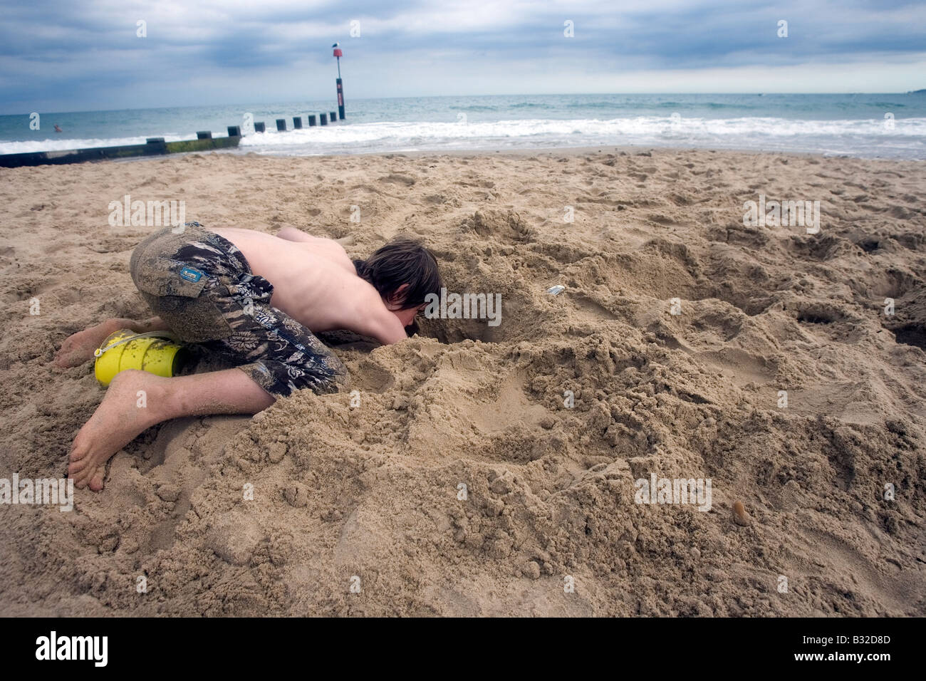 Pic mostra un ragazzo di scavare nella sabbia Foto Stock