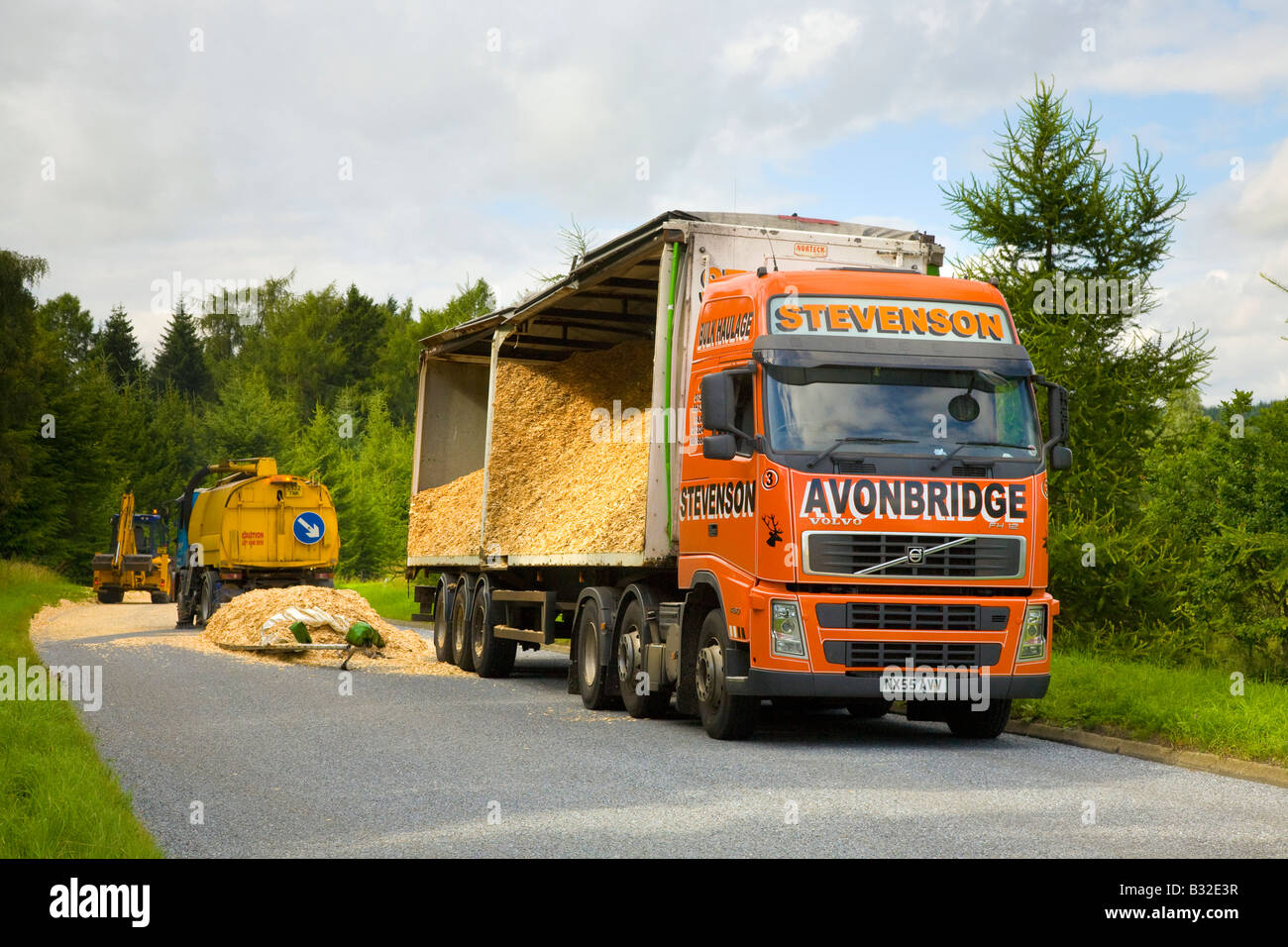 Capovolto merci pesanti camion di legno che spillano legno segheria rifiuti di legno sfuso trucioli di legno. Incidente stradale sulla A93 Braemar per Glenshee Road, Scozia, Regno Unito Foto Stock