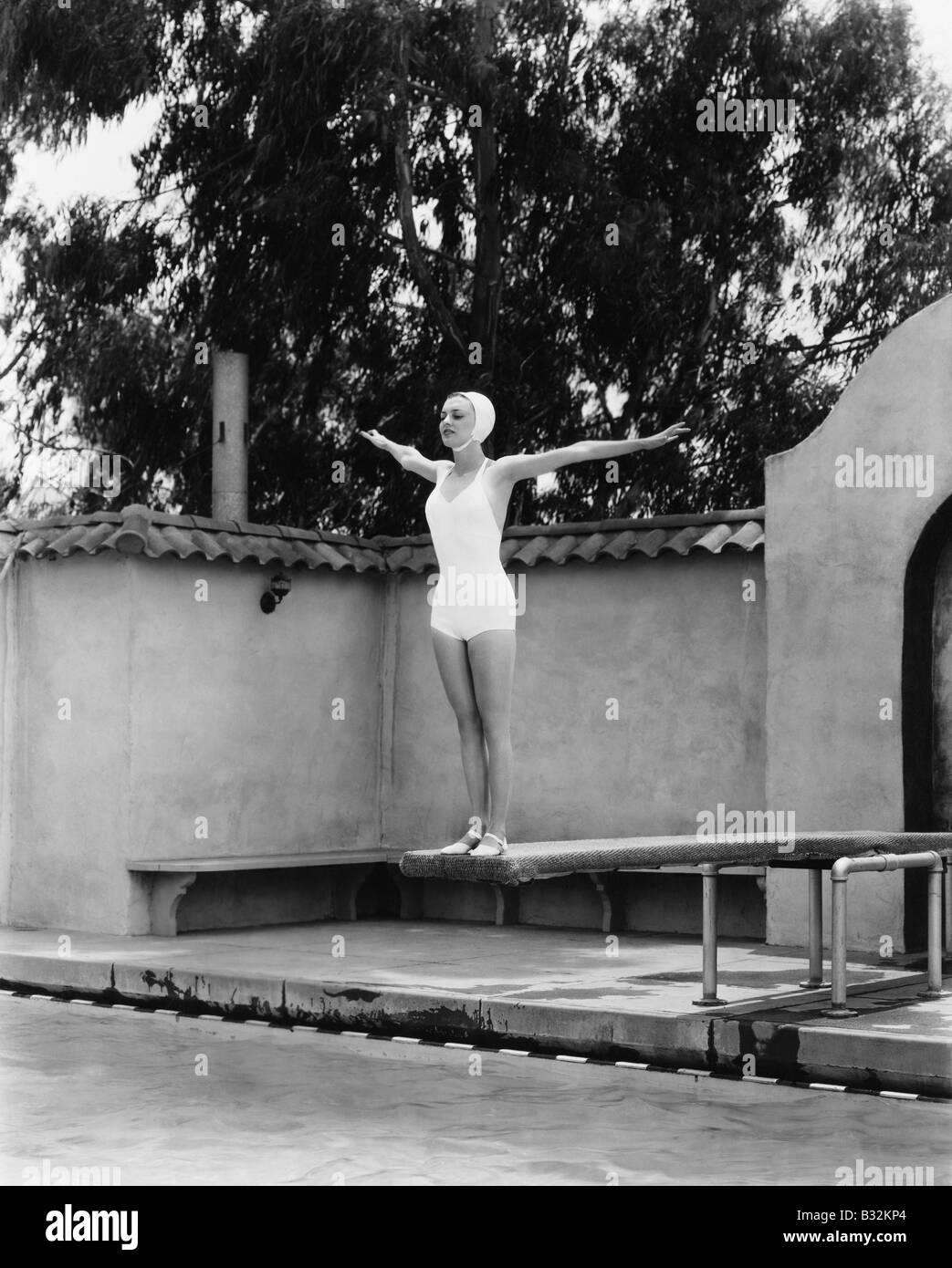 Donna sulla scheda di immersioni in piscina Foto Stock