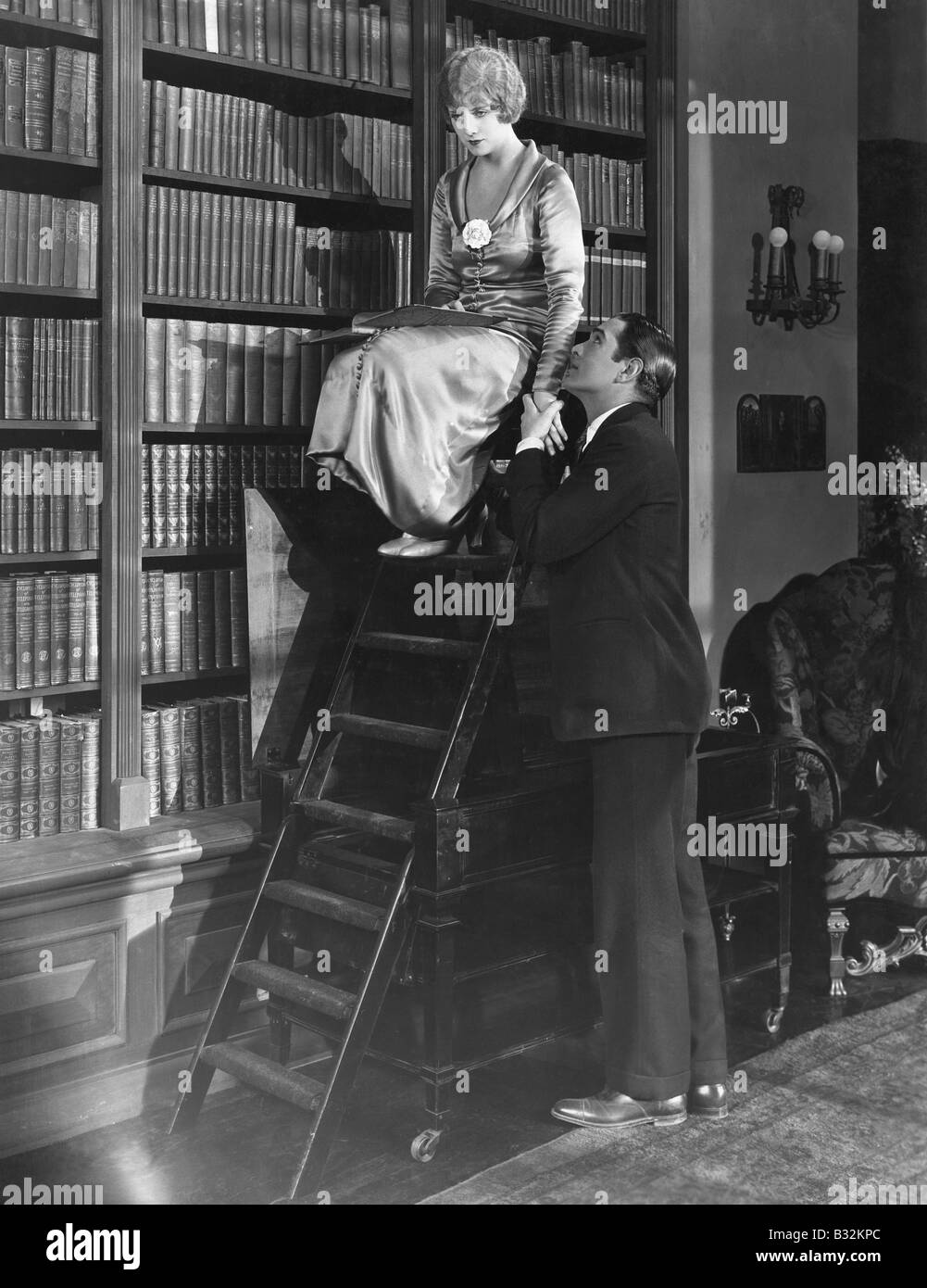 L'uomo con la donna sulla scaletta nella libreria Foto Stock