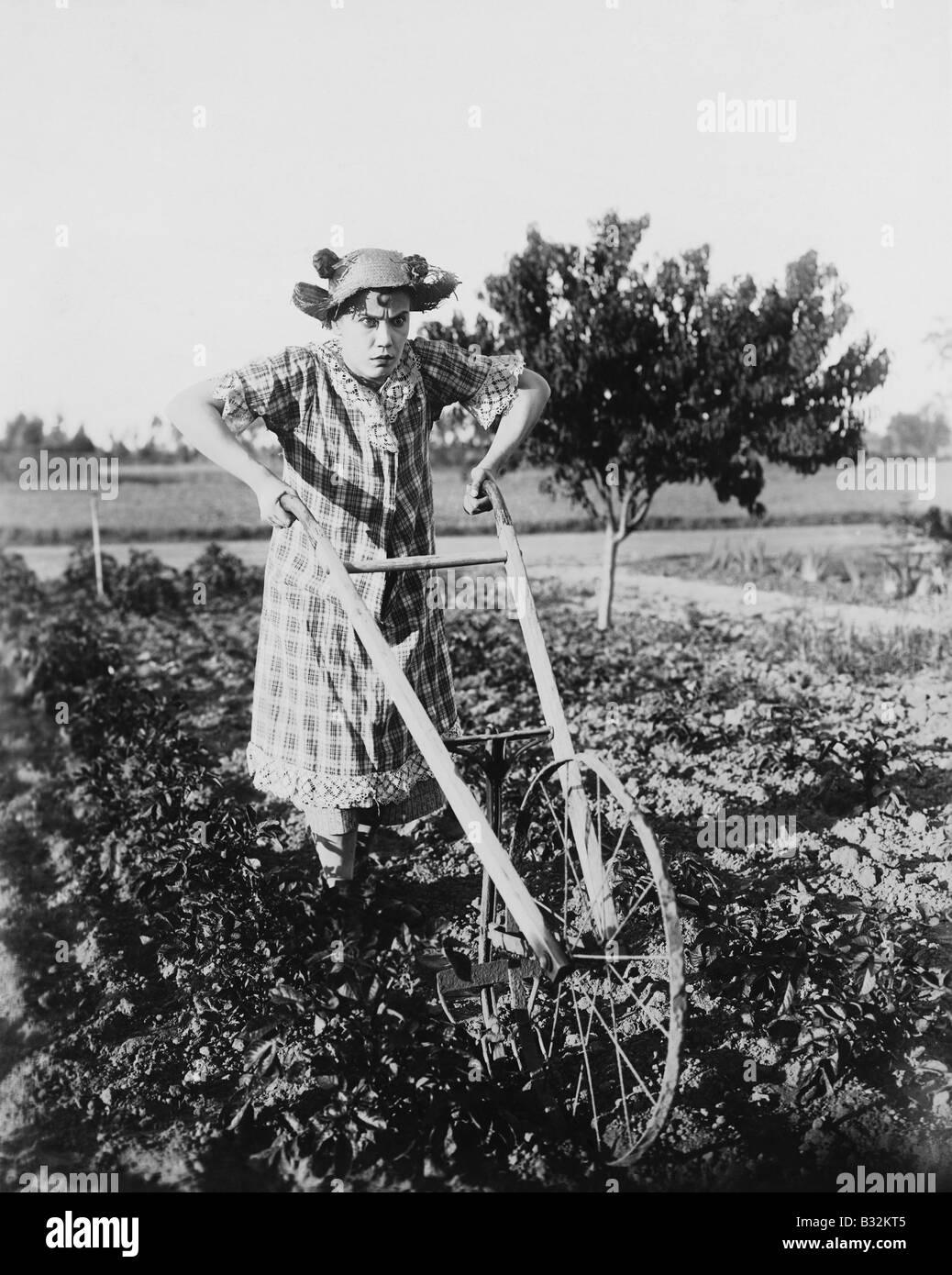 Donna che utilizza pochi aratro in giardino Foto Stock