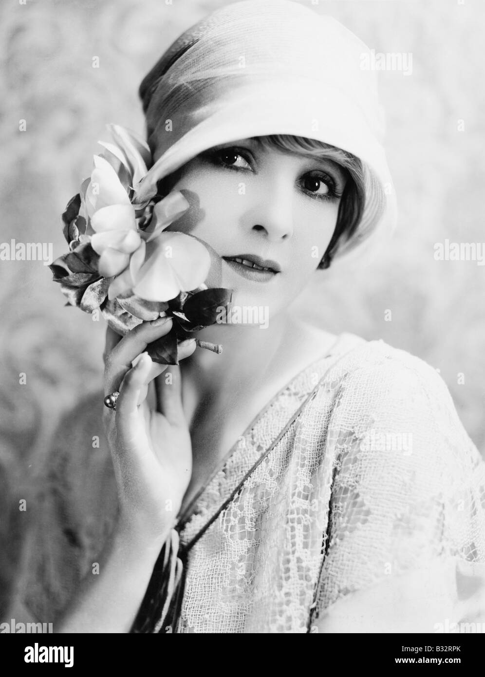 Ritratto di una giovane donna con cappello azienda fiori Foto Stock