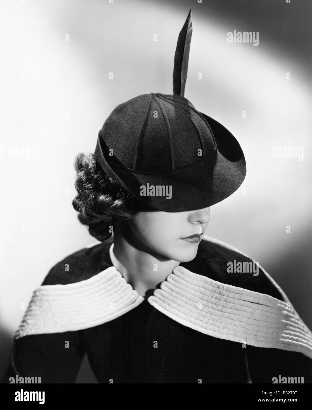 Ritratto di una giovane donna che indossa un cappello con una piuma Foto Stock