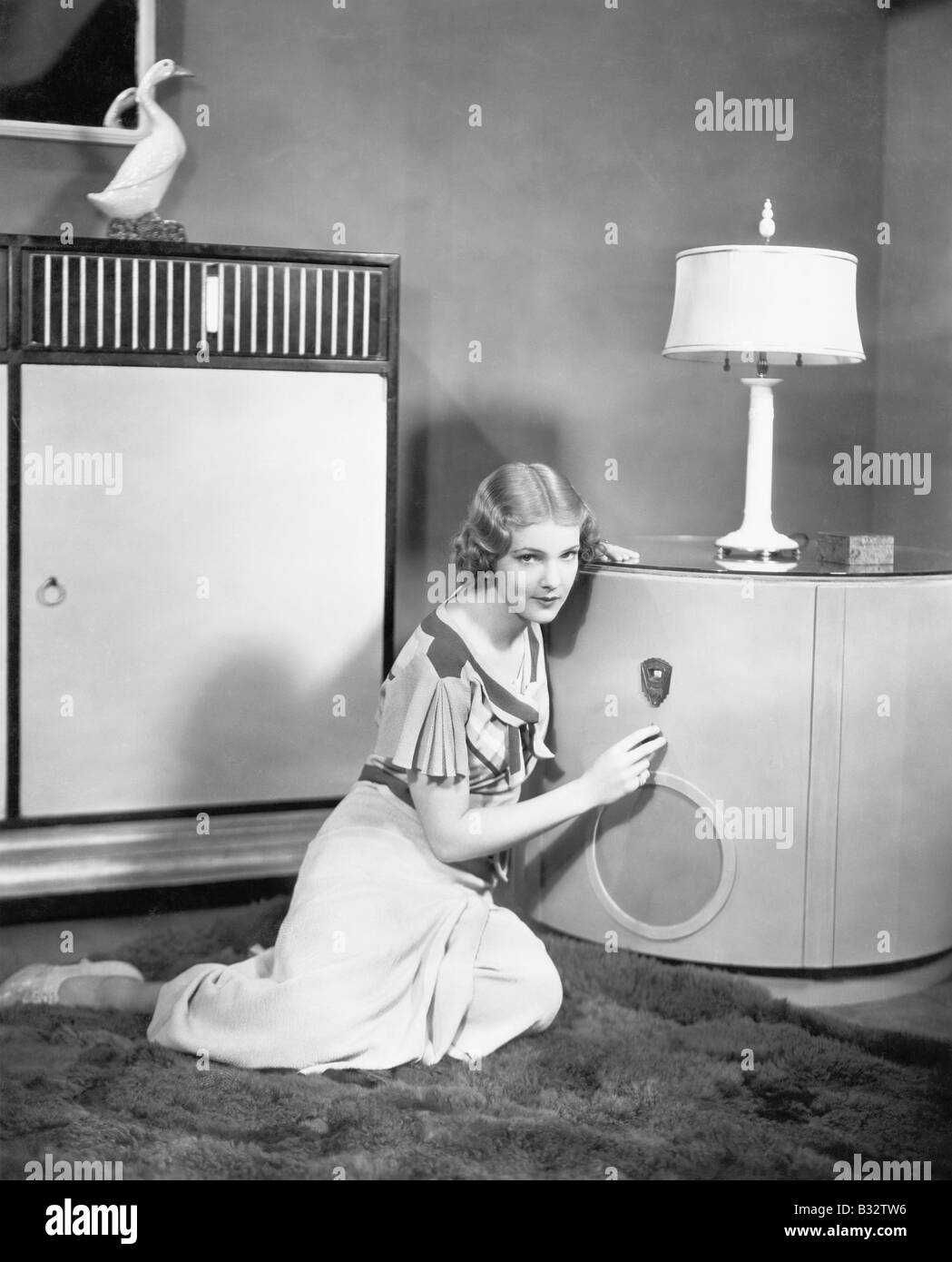 Donna seduta sul pavimento ascoltando la sua radio Foto Stock