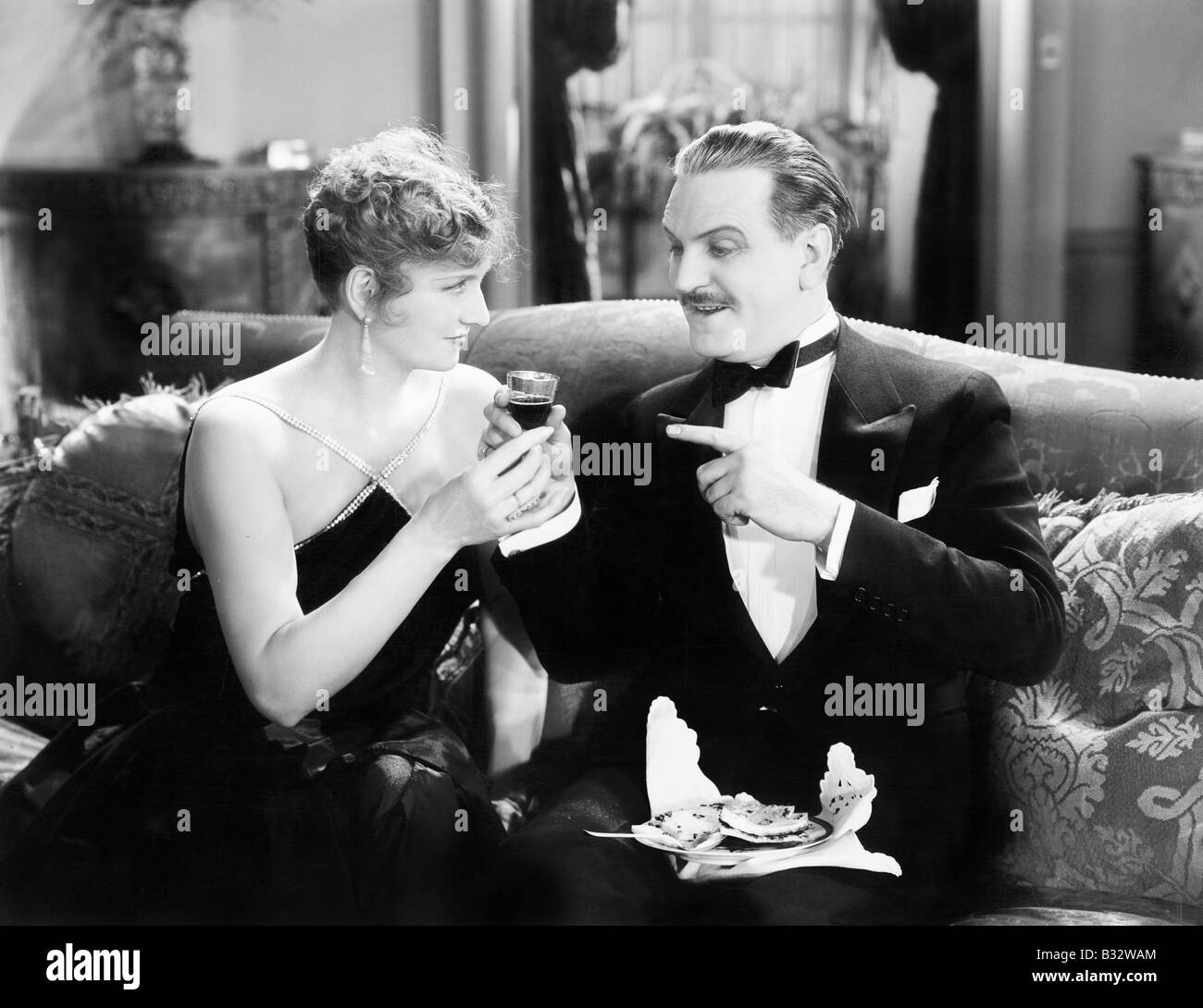 Giovane seduti insieme su un divano e avente un drink Foto Stock