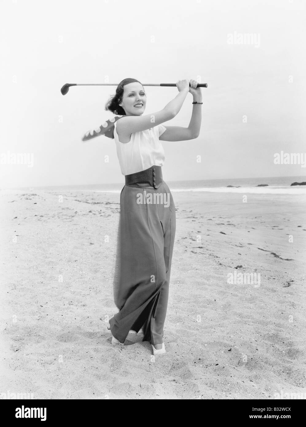 Giovane donna giocando a golf presso il campo da beach Foto Stock