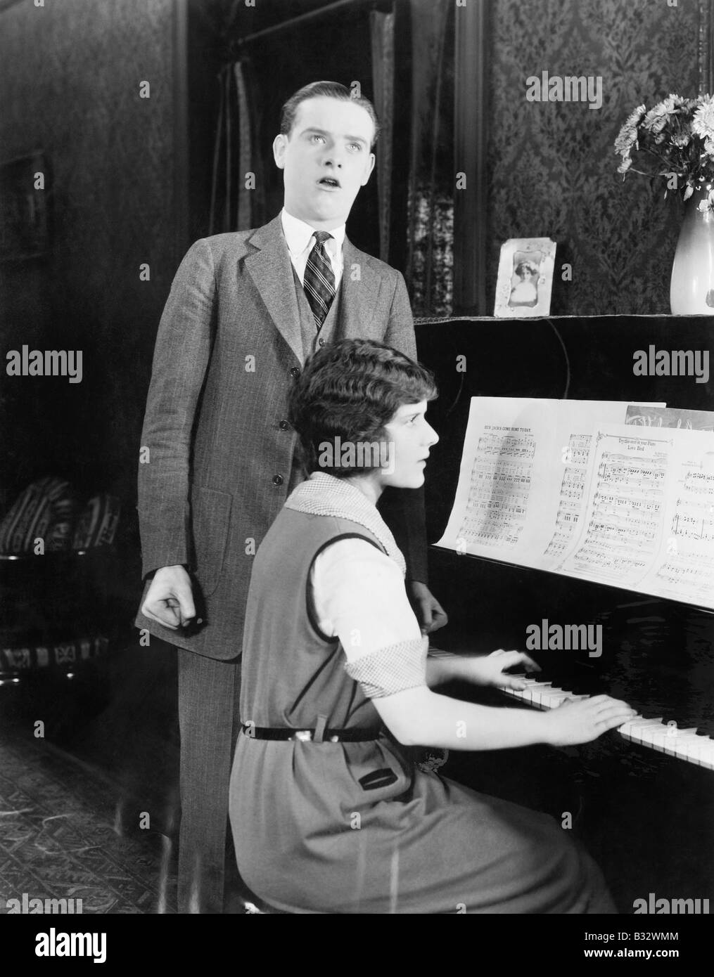 Uomo cantano e donna suonare il pianoforte Foto Stock