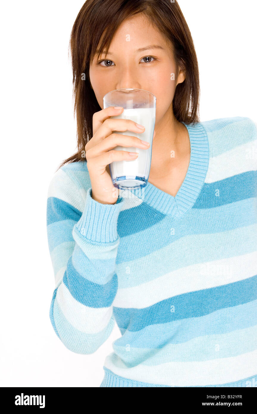 Una giovane donna asiatica di bere un bicchiere di latte Foto Stock