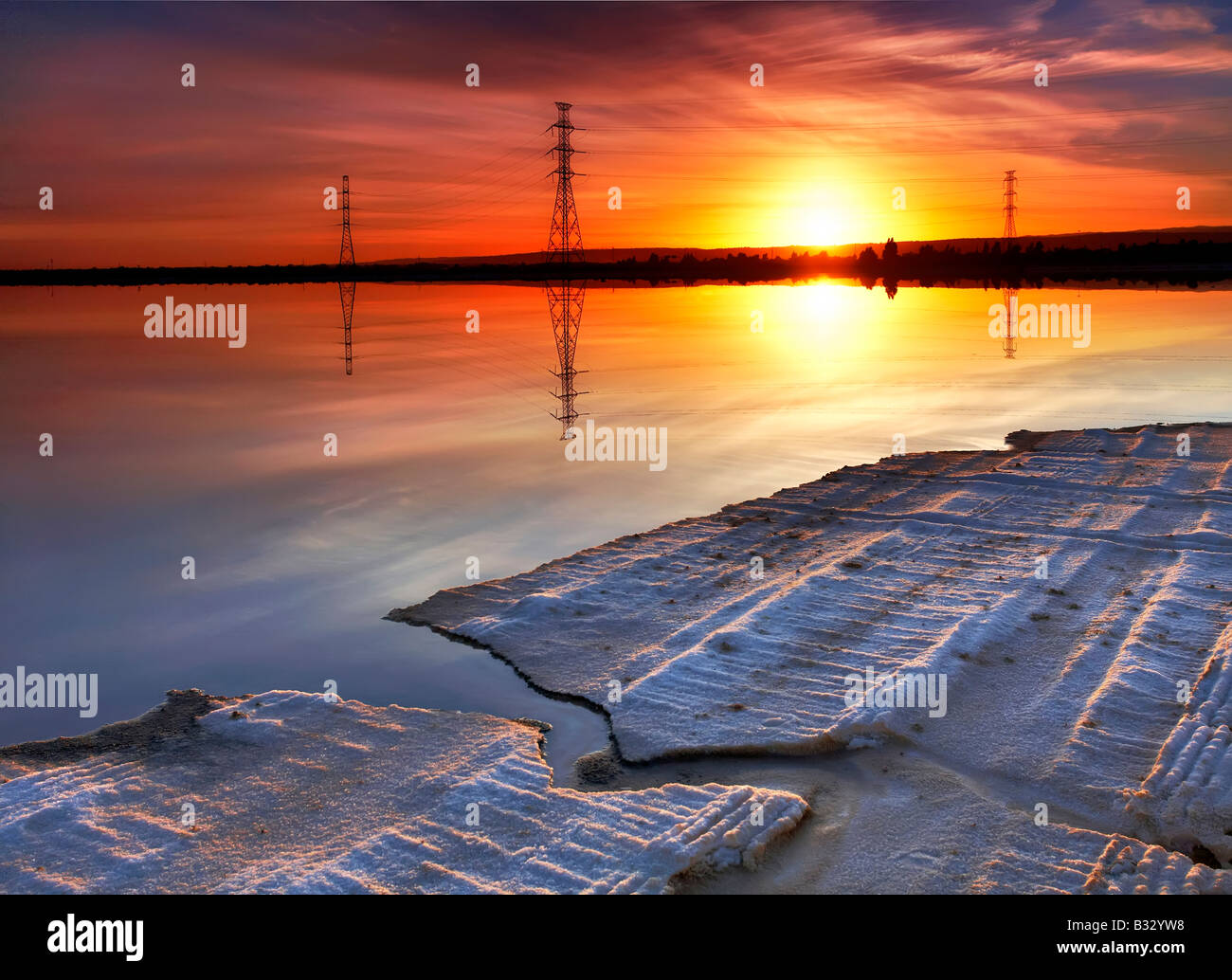 Sunrise saline powerlines riflessione acqua calma Foto Stock