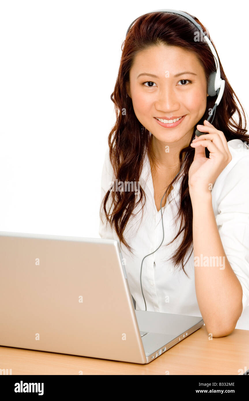 Una bella giovane donna asiatica con il computer portatile e la cuffia pronto per aiutare Foto Stock