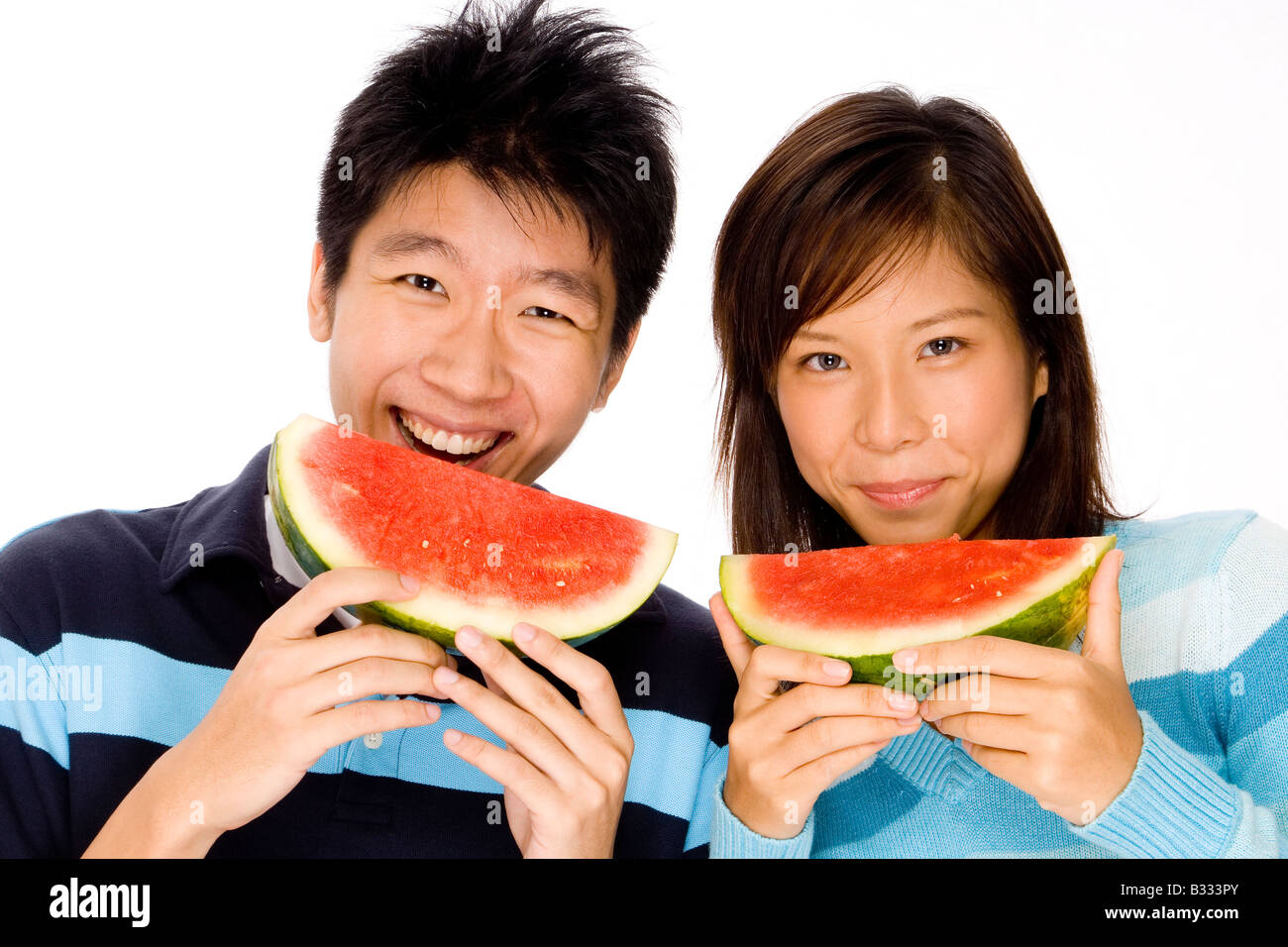 Una bella asiatica di giovane mangiare insieme di melone Foto Stock