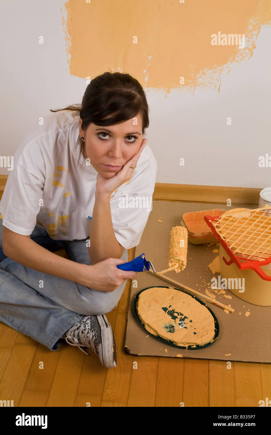 Giovane donna dipinge la sua casa Foto Stock