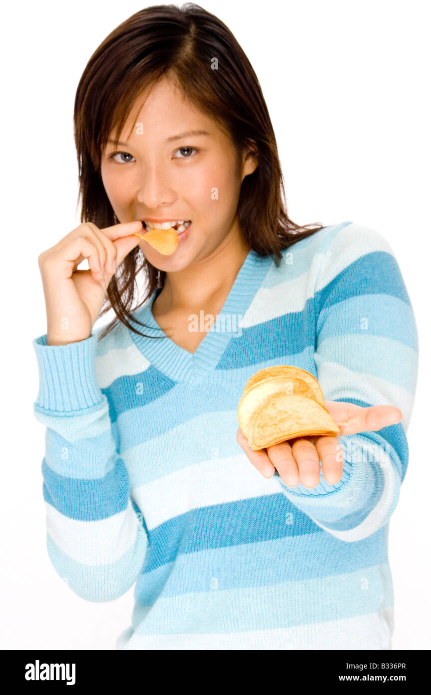 Una bella giovane donna asiatica che offre chip (Focus on chips in mano) Foto Stock