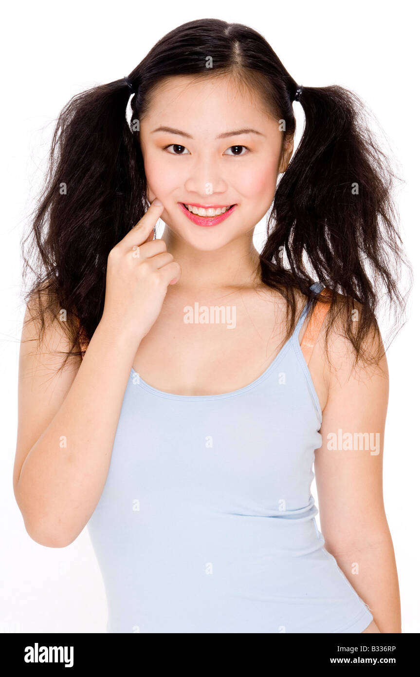 Una giovane donna asiatica in un simpatico pongono Foto Stock