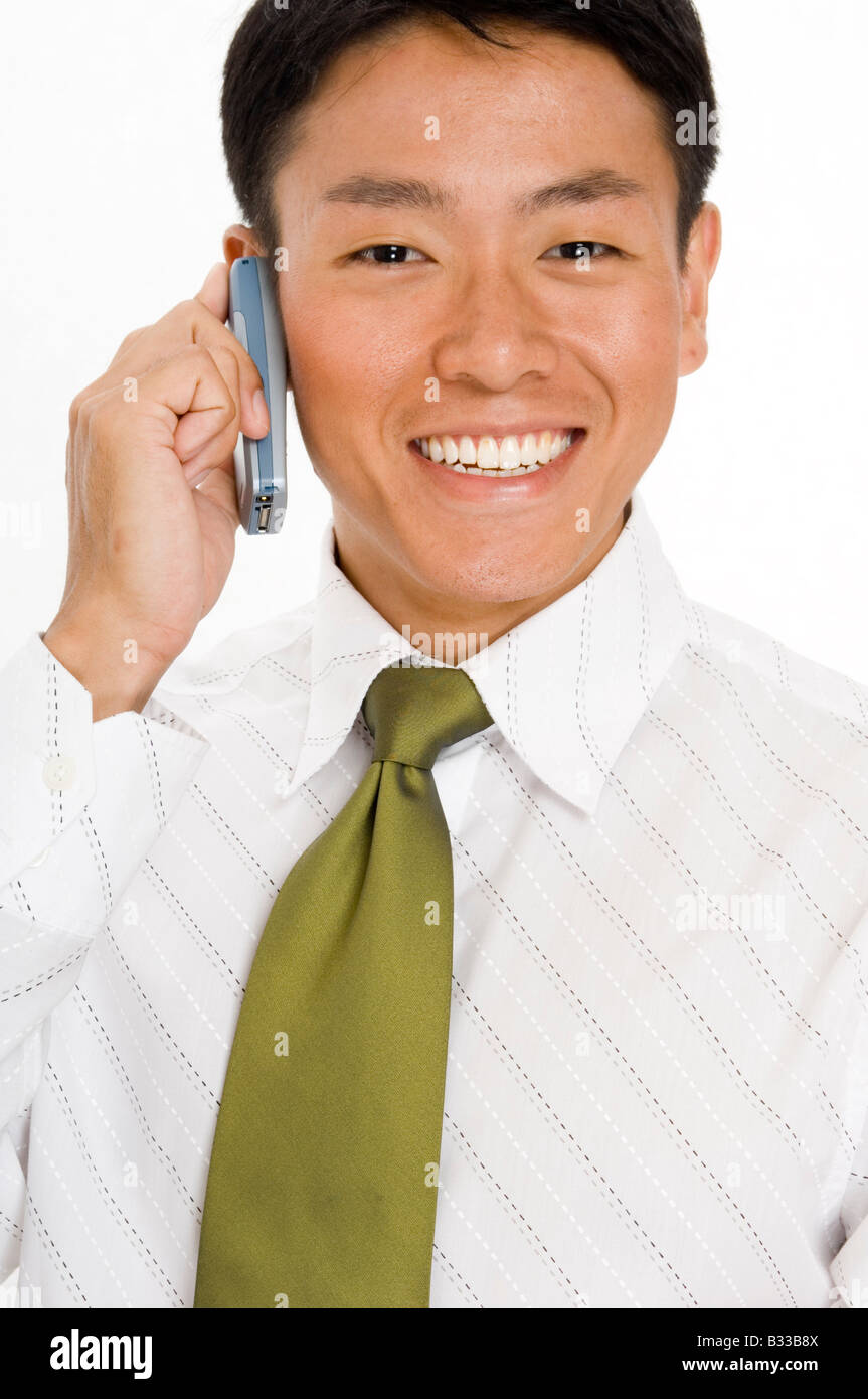 Un felice giovane imprenditore asiatici in possesso di un telefono cellulare Foto Stock