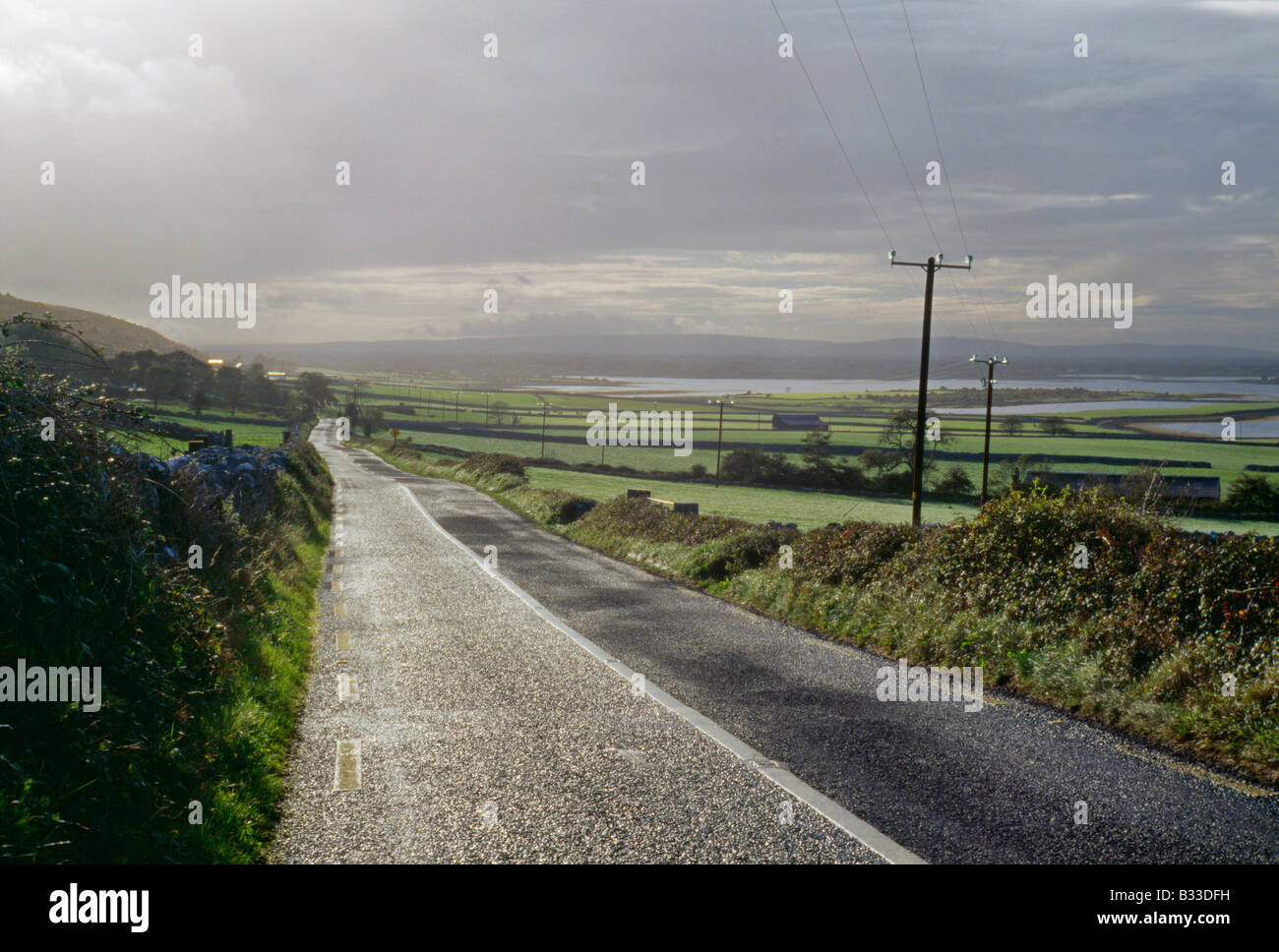 Un County road attraversando County Clare Irlanda Foto Stock