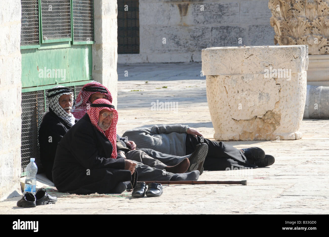 Un gruppo di anziani uomini arabi sedersi nella calura del mezzogiorno nel composto della Moschea di Al-Aqsa (al Monte del Tempio in Gerusalemme. Foto Stock