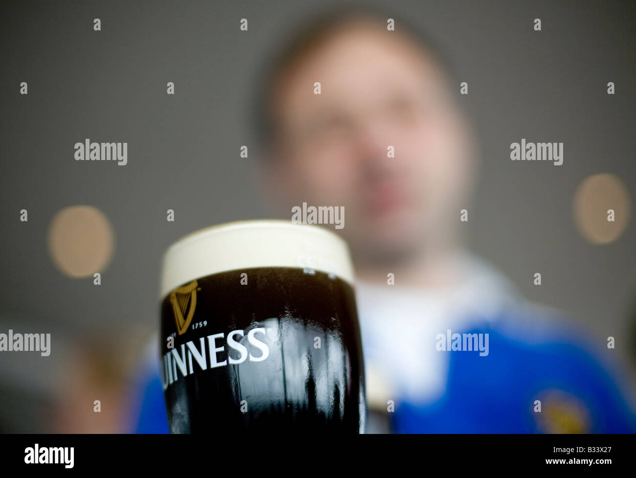 L'uomo ammirando la pinta di Guinness nella circolare Gravity Bar in cima alla Guinness Storehouse in birreria a Dublino Foto Stock