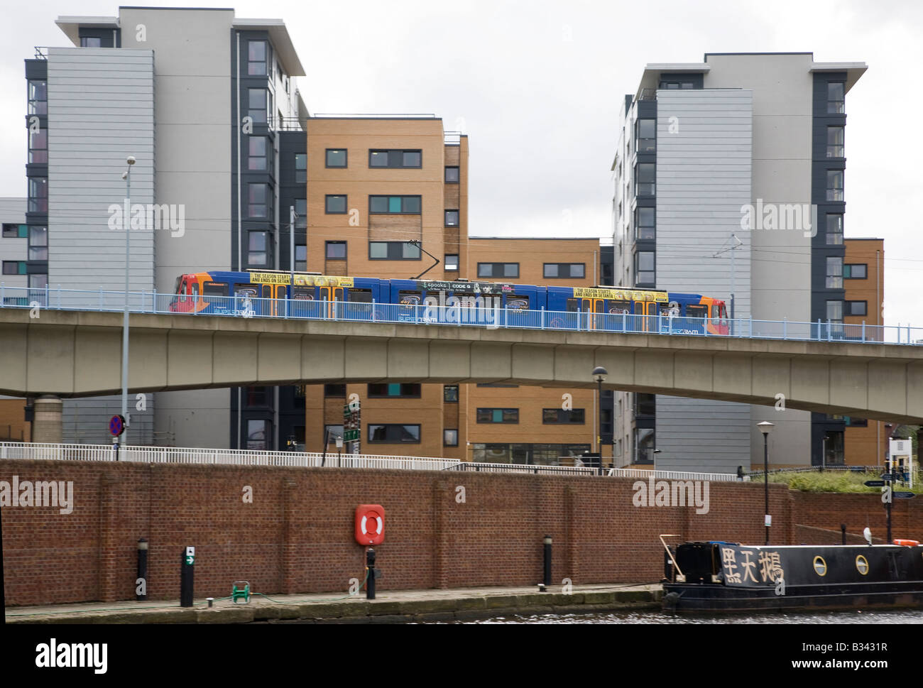 Supertram di Sheffield passando il nuovo sviluppo edilizio visto da Victoria Quay Foto Stock