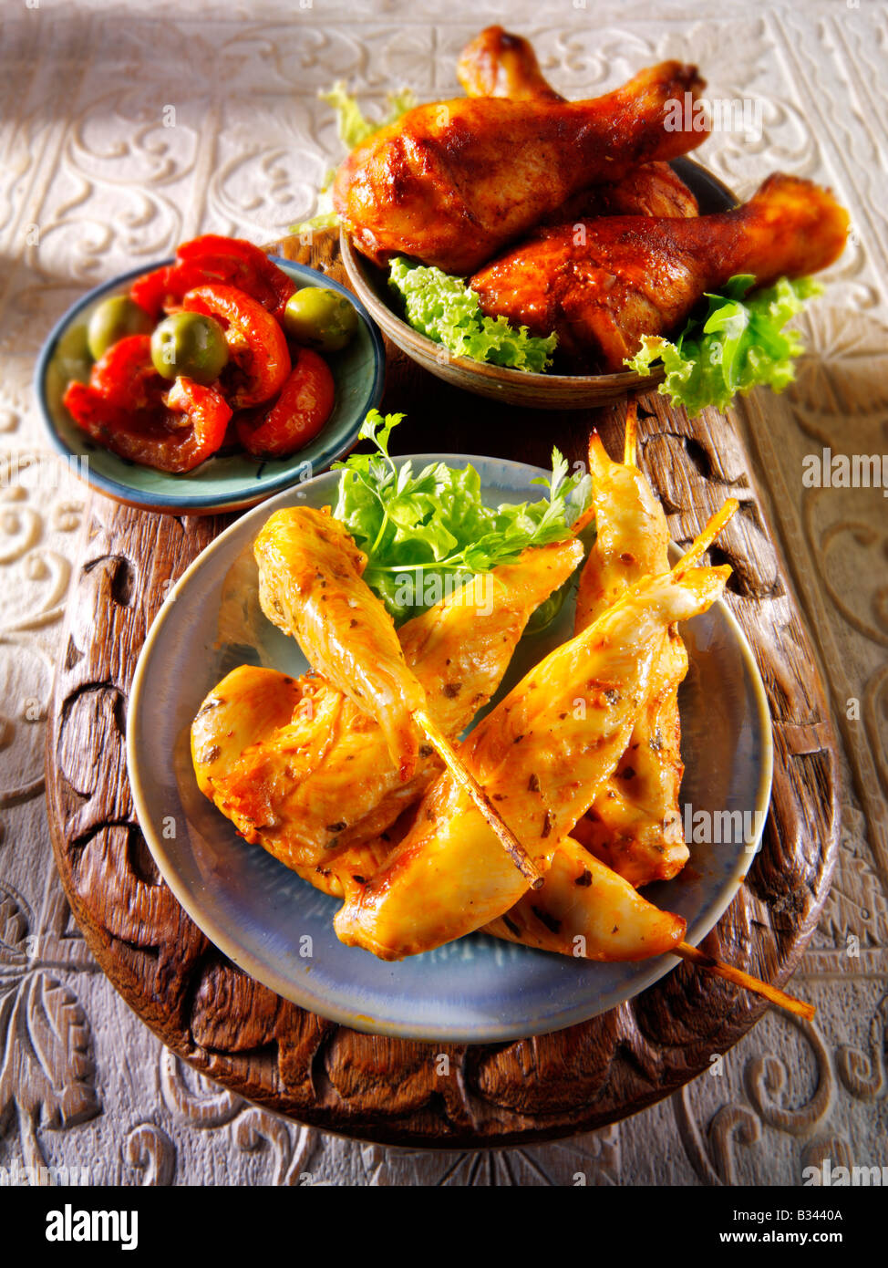 Parte del cibo - dalla parte anteriore - pollo marinato, spiedini di pollo Marinaded tamburo bastoni e sun blushed i pomodori. Foto Stock