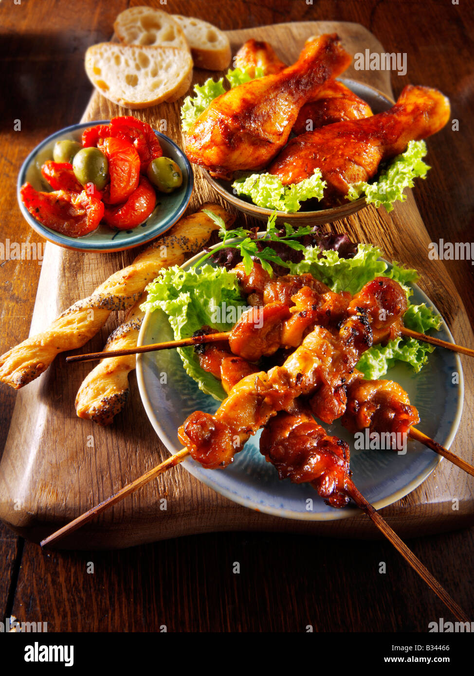 Cibo per barbecue - dalla parte anteriore - Yakitori di pollo, Marinaded tamburo di pollo bastoncini e sun blushed i pomodori. Foto Stock