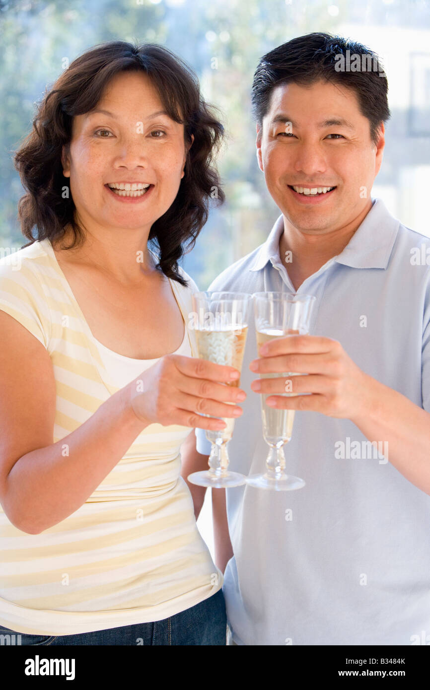 Paio di champagne di tostatura e sorridente Foto Stock