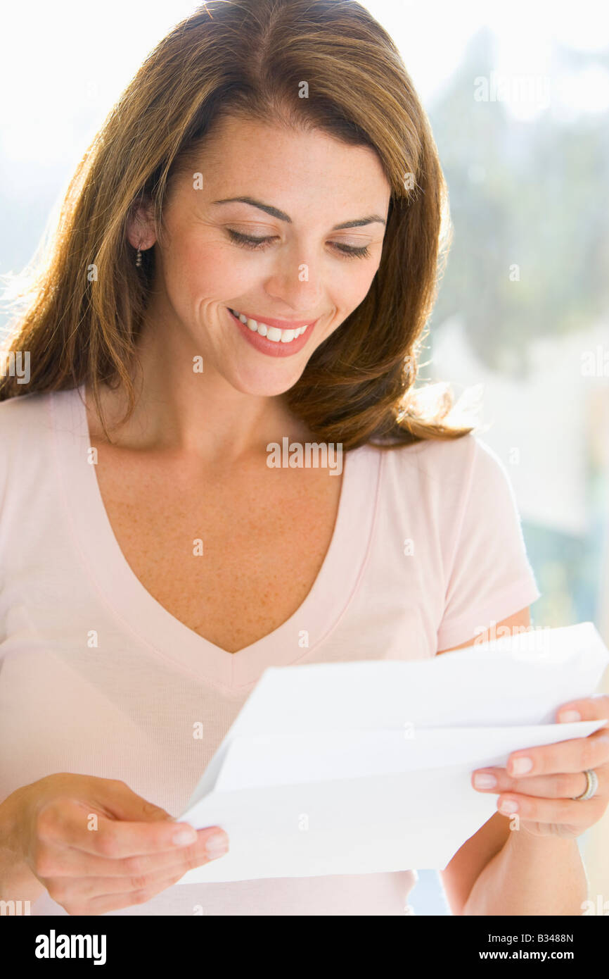 Donna lettura la lettera sorridente Foto Stock