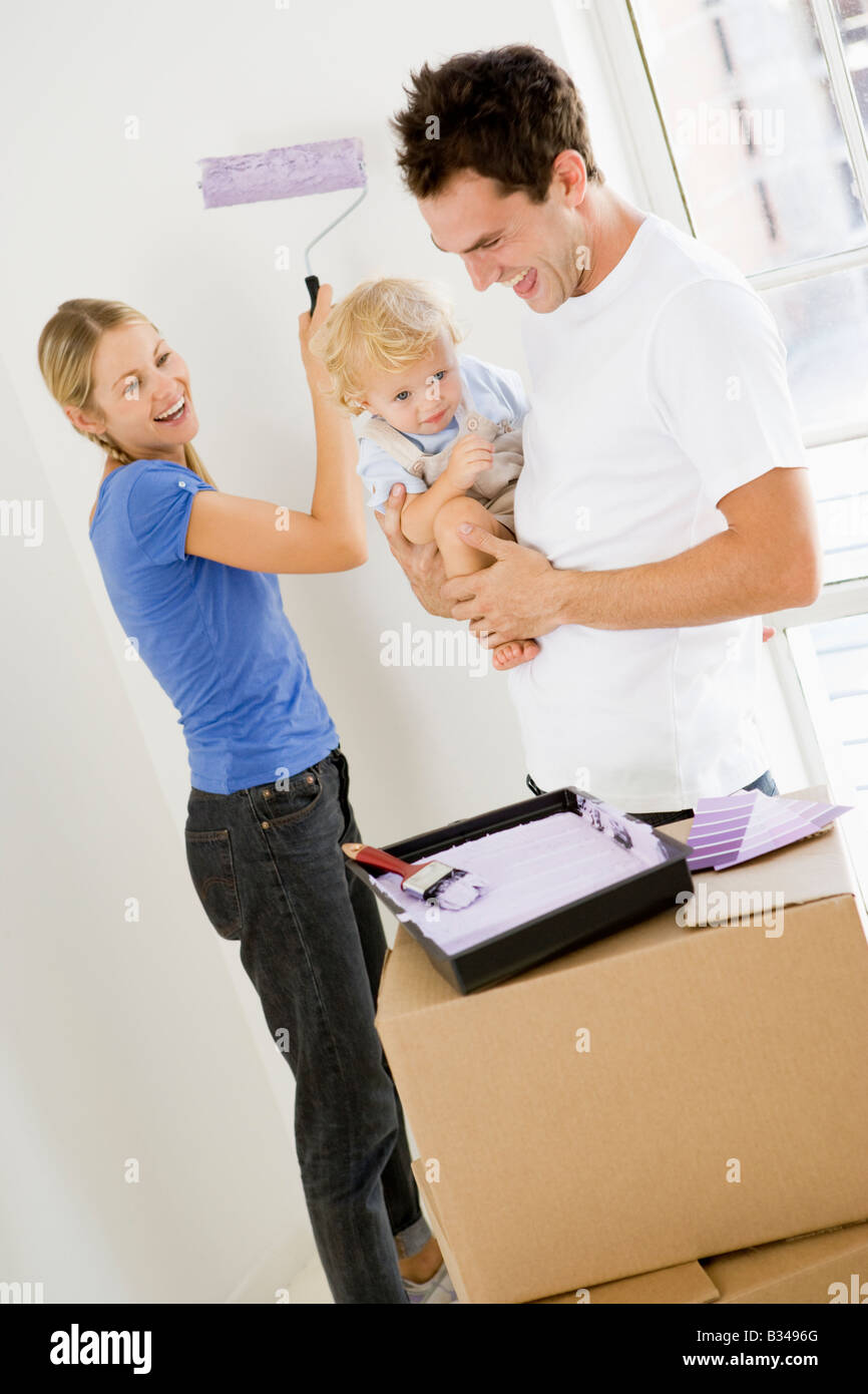 Famiglia camera di verniciatura nella nuova casa sorridente Foto Stock