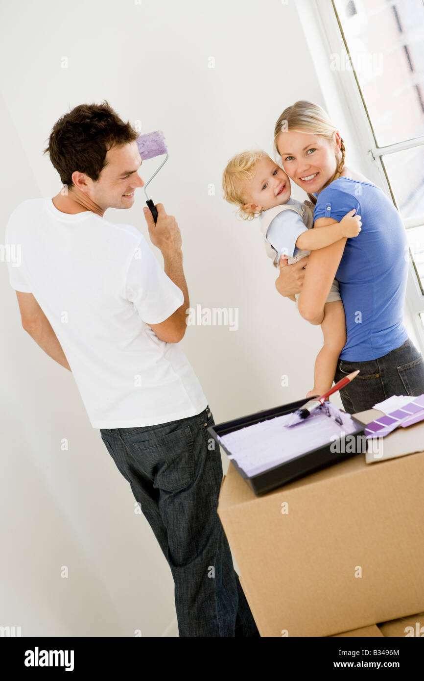 Famiglia camera di verniciatura nella nuova casa sorridente Foto Stock
