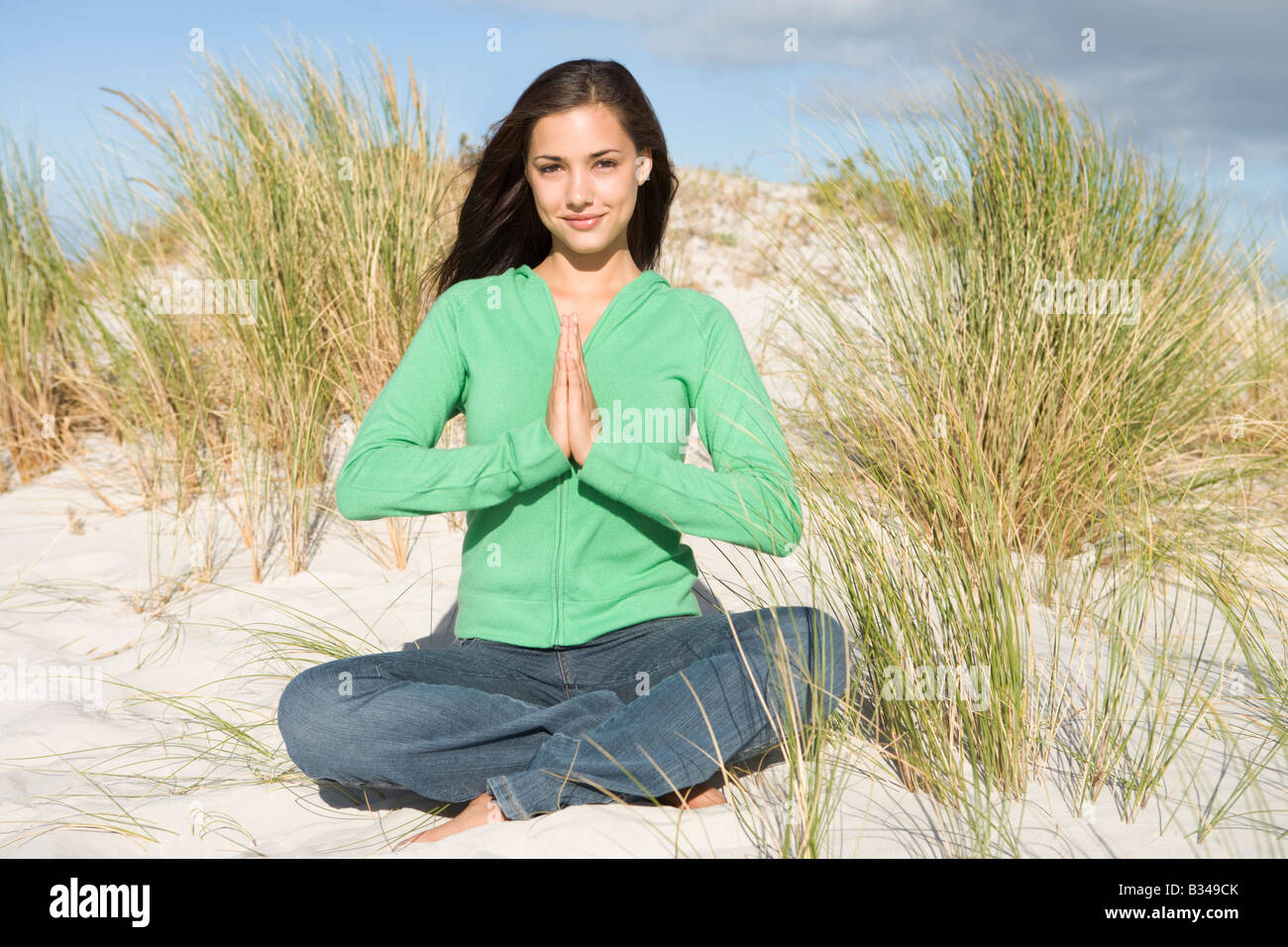 Giovane donna in posa su una collina di sabbia Foto Stock