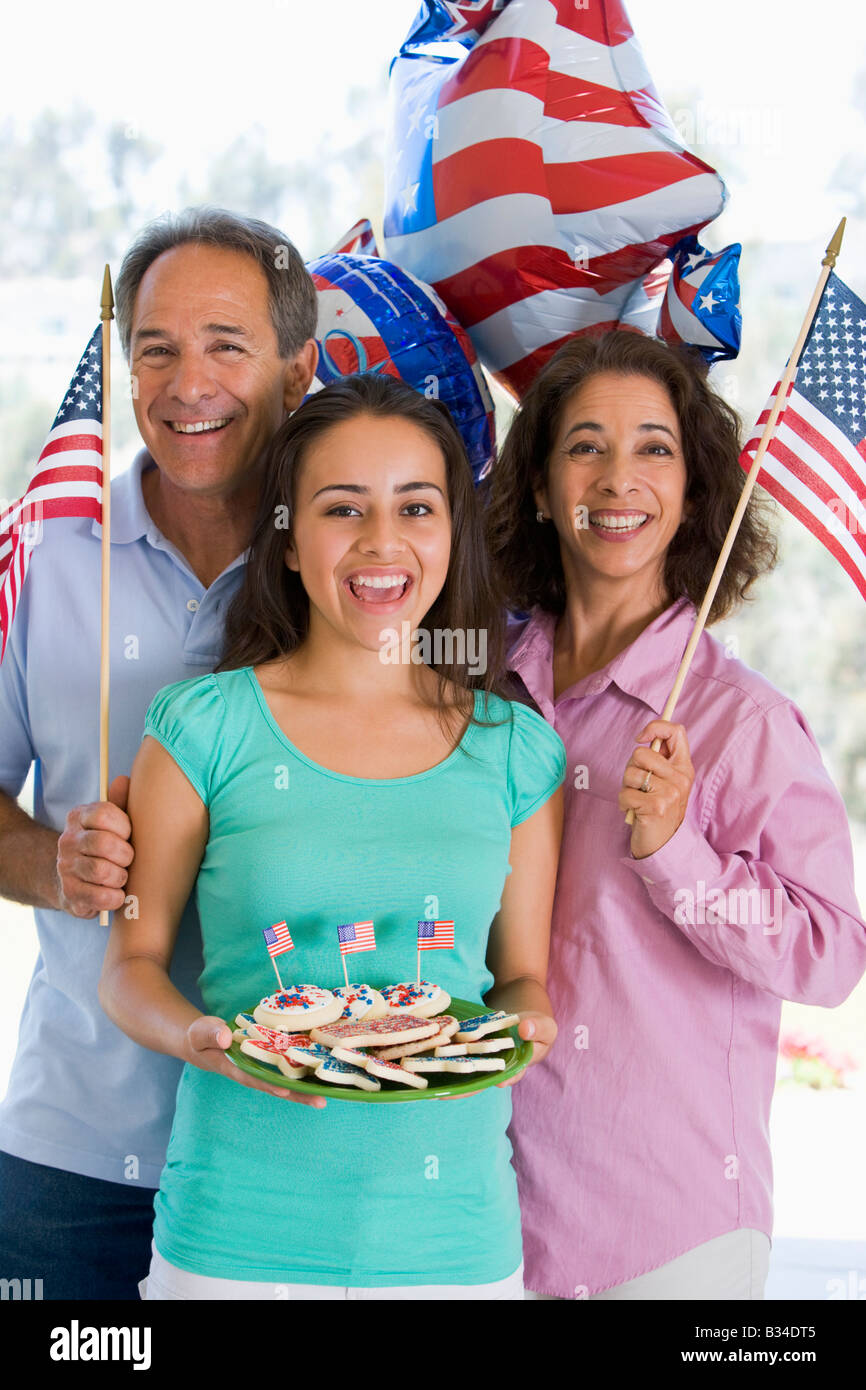 Famiglia all'aperto sul quarto di luglio con bandiere e cookie sorridente Foto Stock