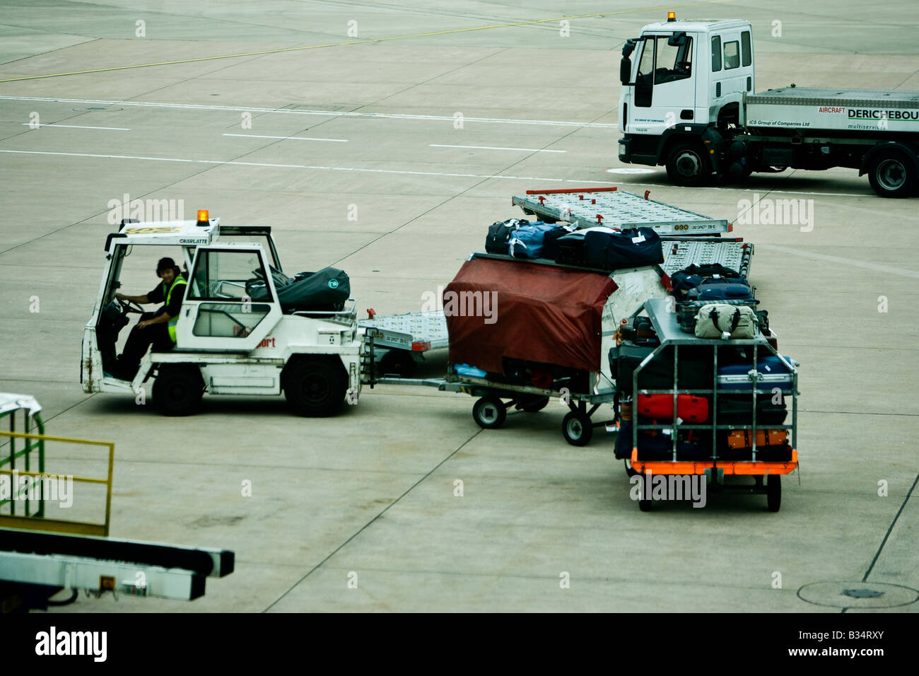 Gestore di bagaglio moveing bagagli in aeroporto lato aria British Airport Manchester International Foto Stock