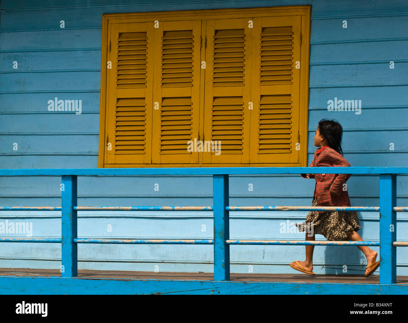 Giovani cambogiani Khmer schoolgirl in esecuzione passato un otturatore giallo Chong Khneas Tonle Sap (lago Tonle) Cambogia Foto Stock