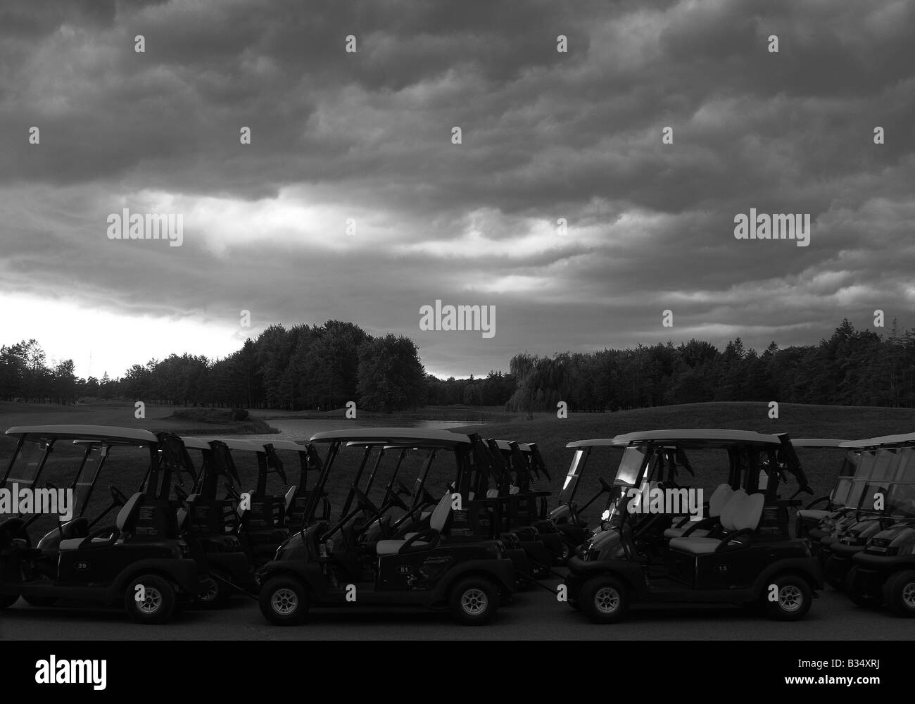 Golf carts rivestito fino ad un campo da golf come una tempesta davanti si avvicinò, ponendo fine ad un golfer's round. Queste nubi minacciose. Foto Stock