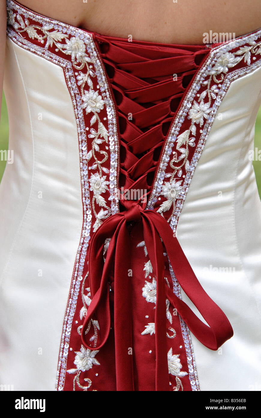 Il retro di una sposa rosso e bianco abito da sposa che mostra la legatura,  la decorazione e la prua Foto stock - Alamy