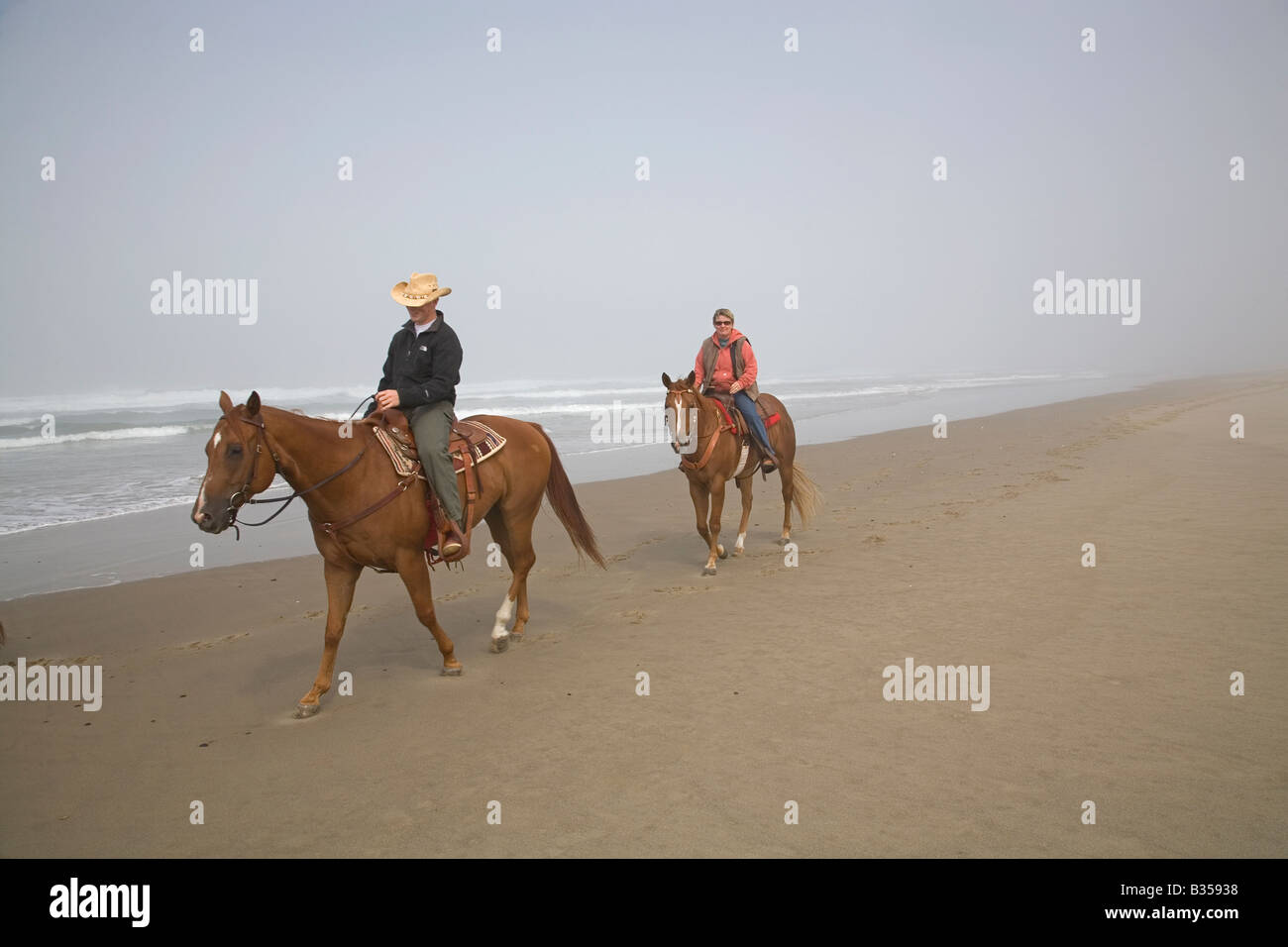 Equitazione sulla vasta spiaggia di sabbia nella baia di nehalem parco dello stato sulla costa dell'Oregon Foto Stock