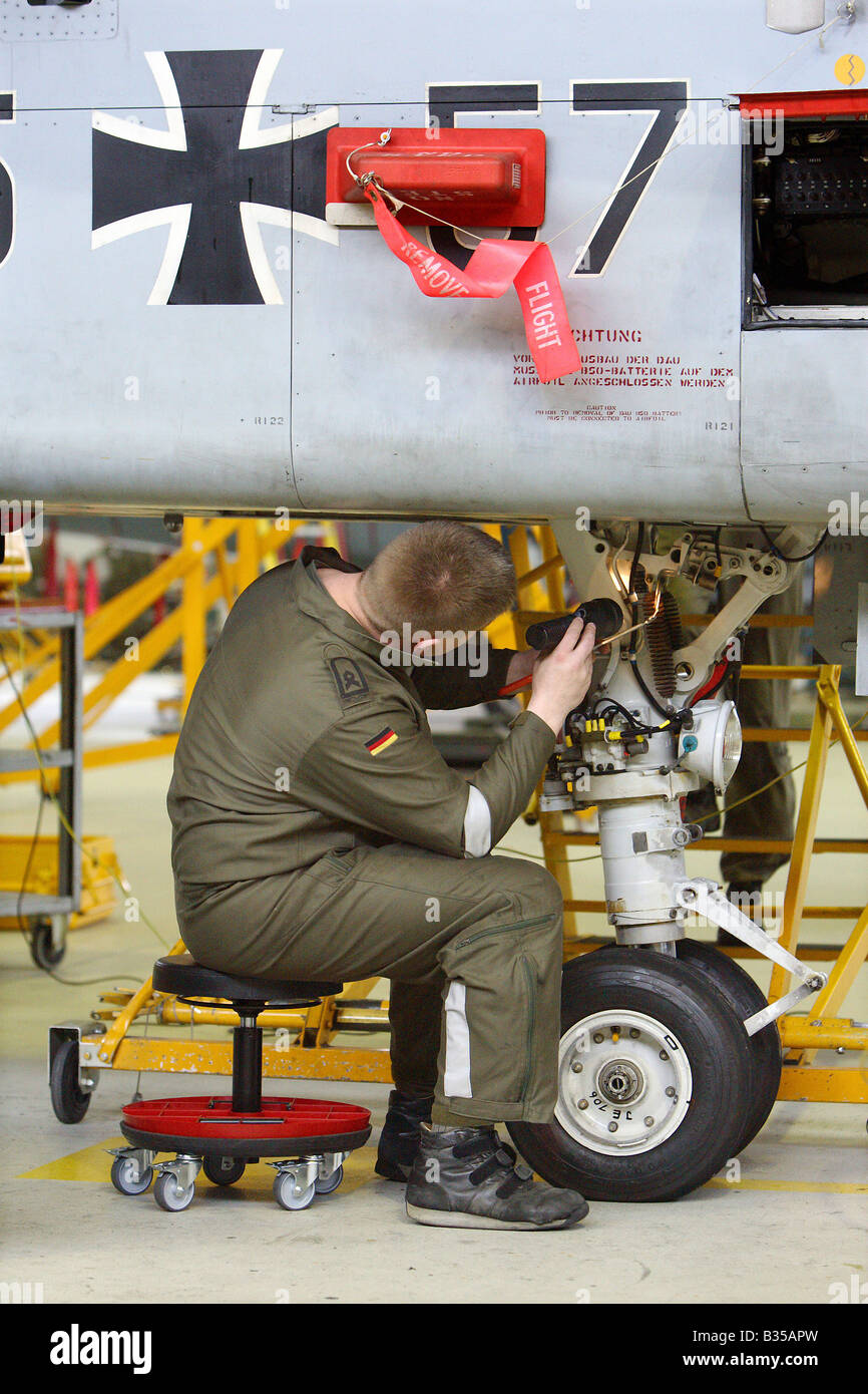 Un meccanico di controllo del carrello di atterraggio di un jet da combattimento, Jagel, Germania Foto Stock