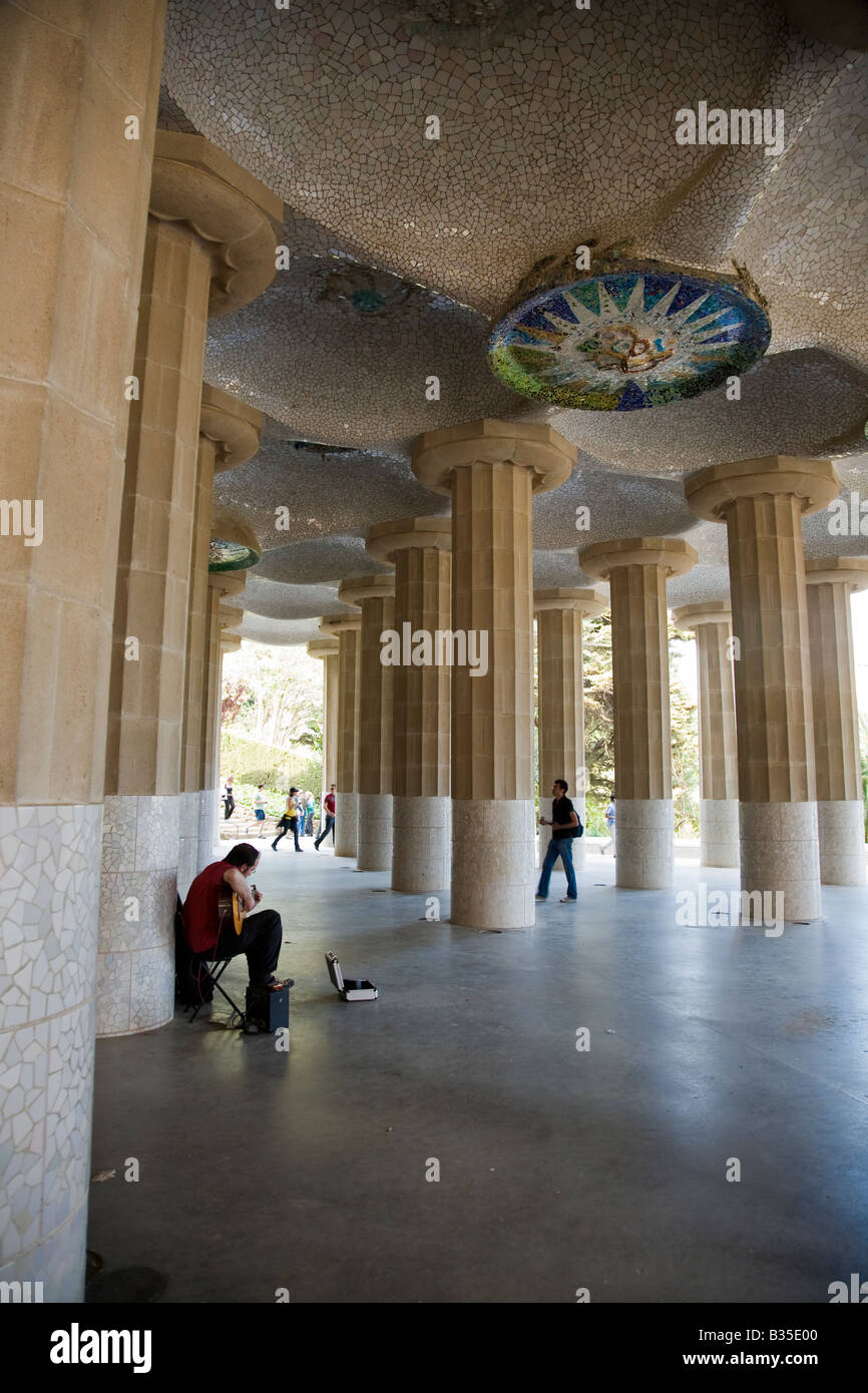 Spagna Barcellona uomo suonare la chitarra nella Hall di 100 colonne Parc Guell progettato Antoni Gaudi architetto architettura Modernisme Foto Stock