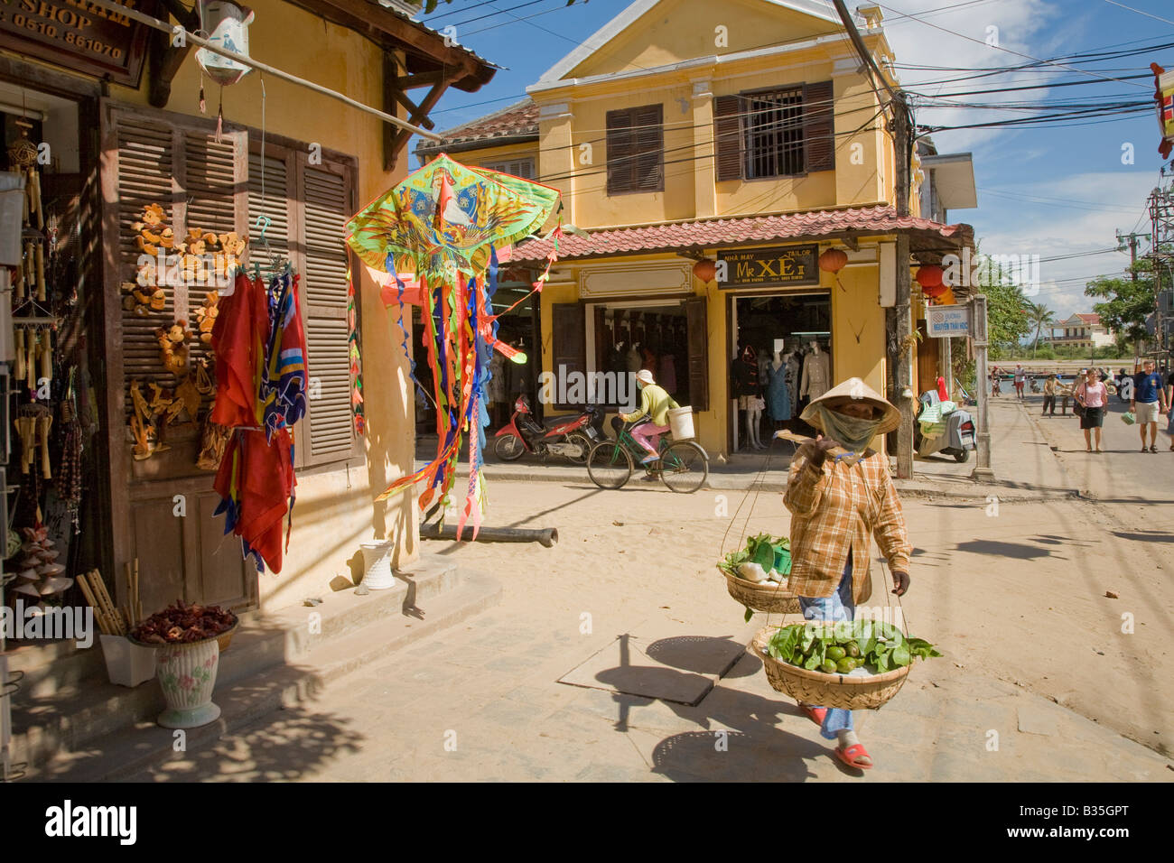 Una donna di capi per il mercato giornaliero in Hoi An, Vietnam Foto Stock