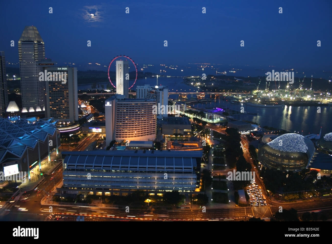Lo skyline di Singapore di notte sul lato del porto e Esplanade con una luna piena , Singapore Sud Est asiatico Foto Stock
