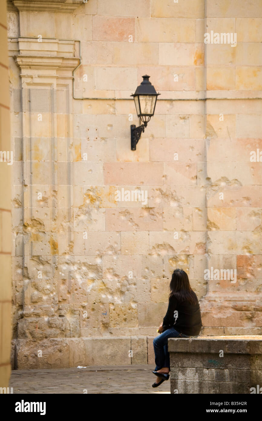 Spagna Barcellona donna sedersi sul bordo della fontana pockmark danni dalla guerra civile spagnola bombe sulla chiesa di San Felip Neri in plaza Foto Stock