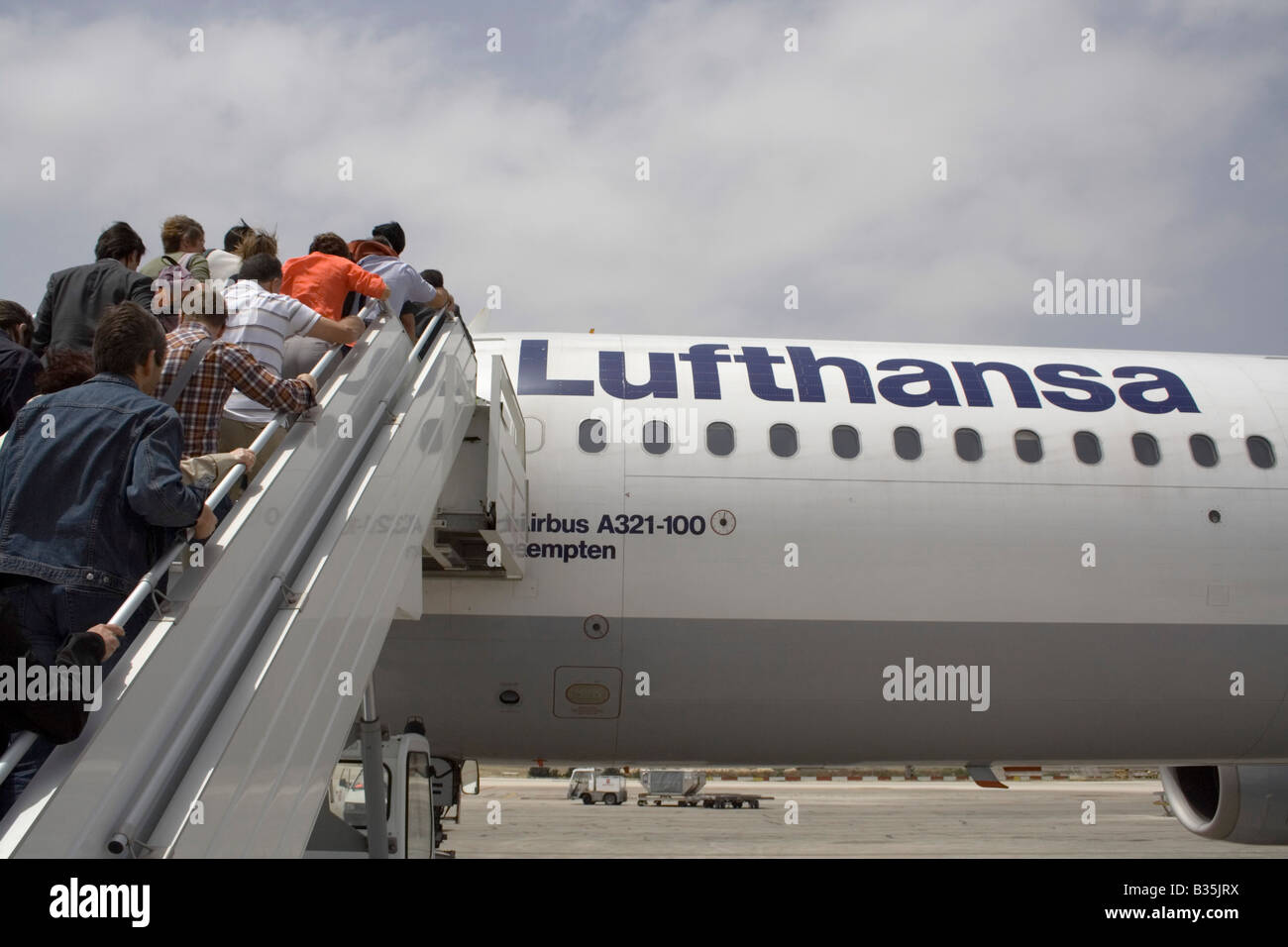 Commerciale viaggi dell'aria. I passeggeri di salire a bordo di un Lufthansa Airbus A321 aereo di linea per mezzo di una scala mobile o di una rampa di scale Foto Stock