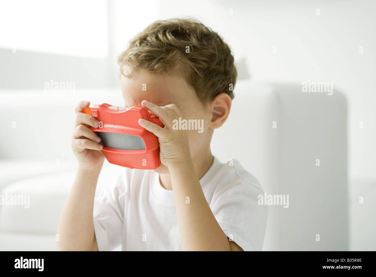 Little Boy cercando in giocattolo view finder Foto Stock