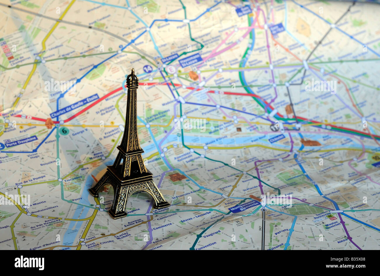 Un piccolo modello in scala della torre Eiffel in piedi su una mappa di Parigi, Francia Foto Stock