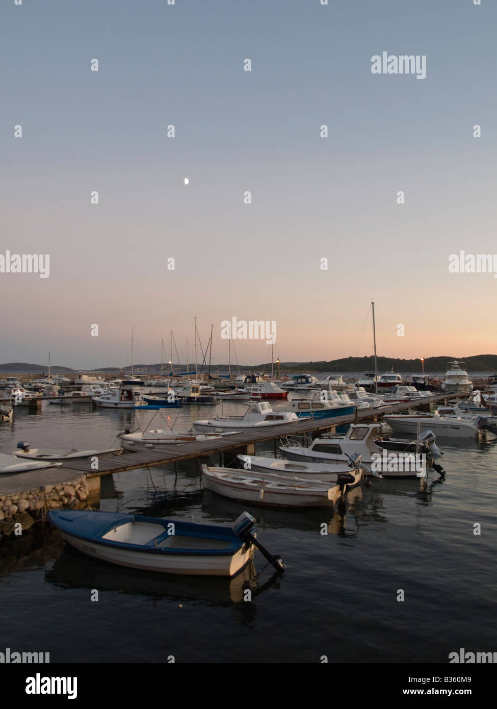 Fotografia di un porto con molte piccole navi al tramonto. Foto Stock