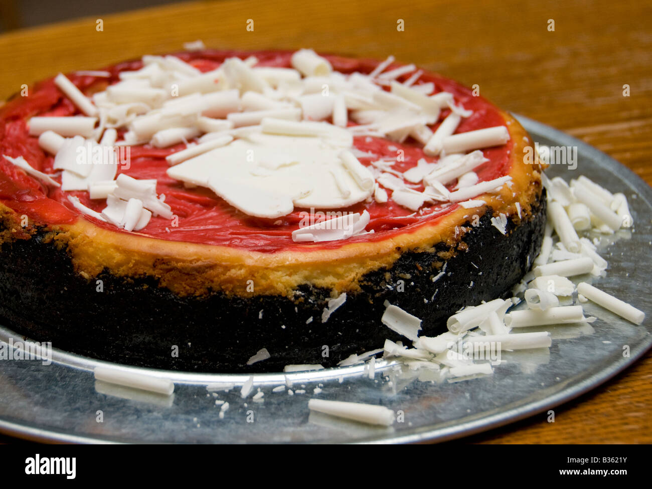 Un Lampone Cheesecake al cioccolato fatto con una chocolate crumb crosta con scaglie di cioccolato bianco sulla parte superiore di una salsa di lamponi. Stati Uniti d'America Foto Stock