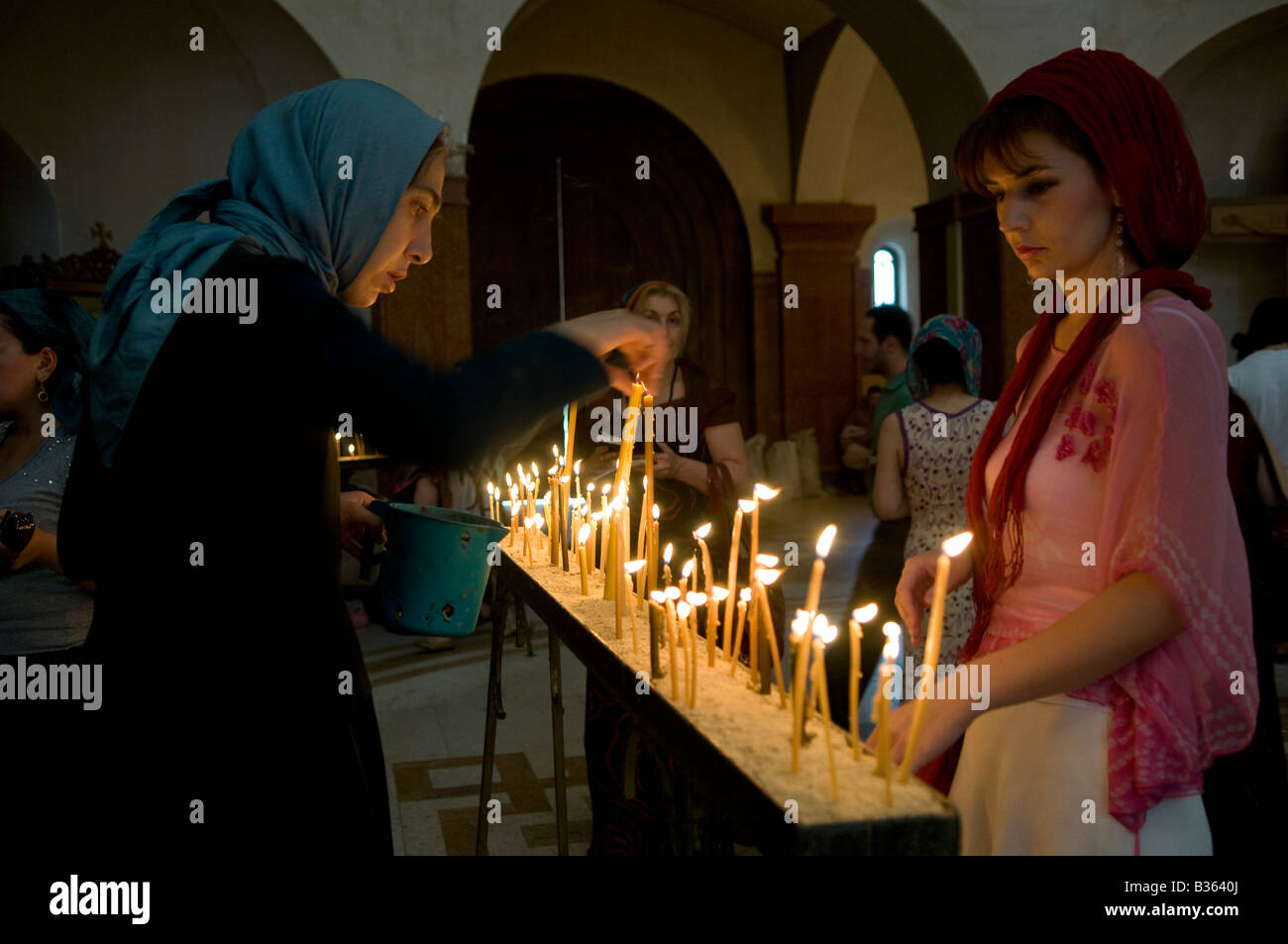 Le donne georgiane illuminano le candele mentre pregano all'interno della Cattedrale della Santissima Trinità, comunemente conosciuta come la cattedrale di Sameba a Tbilisi, Repubblica di Georgia Foto Stock