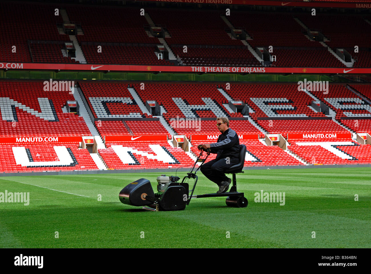 Un groundsman il taglio dell'erba a Old Trafford casa del manchester united football club, Manchester, Inghilterra, Regno Unito Foto Stock